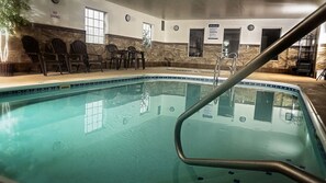 A swimming pool with a tiled edge, a 'No Diving' sign, and a 'Spa Rules' sign on the wall.