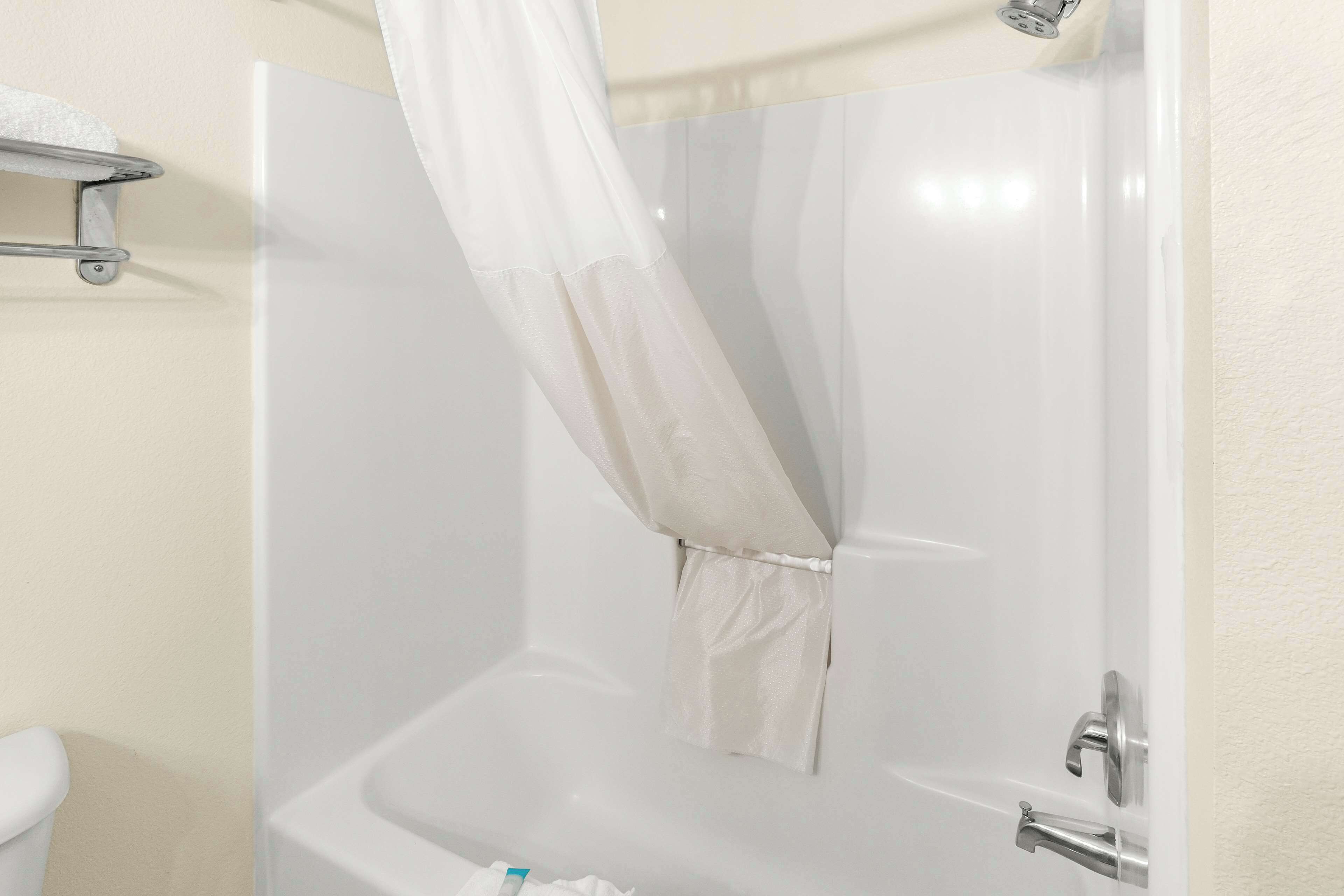 Un baño con bañera, inodoro y cortina de ducha.