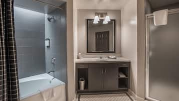 A modern bathroom with a bathtub, shower, and sink.