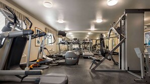 A gym with treadmills, elliptical machines, and weightlifting equipment. - Baymont by Wyndham Hearne (Hearne)