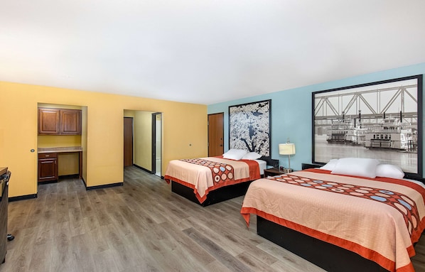 Habitación de hotel con dos camas, kitchenette y un amplio ventanal con vista a la ciudad.