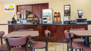 A breakfast area with a counter, coffee machines, a microwave, and seating. - Days Inn by Wyndham Norton (Norton)