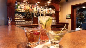 A bar area with various bottles and glasses on shelves.