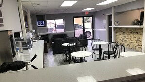 A modern interior with a counter, seating area, and a TV screen. - Express Inn (Weslaco)