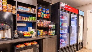 Un espace de restauration en libre-service équipé d’une machine à café, d’un four à micro-ondes et d’un réfrigérateur rempli de collations et de boissons.