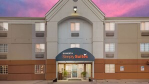A hotel with a modern design, featuring a prominent entrance and a sign for 'Sonesta Simply Suites'.