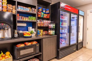 A self-service food station with a coffee machine, microwave, and refrigerator stocked with snacks and beverages. - Sonesta Simply Suites Oklahoma City Airport (Oklahoma City)