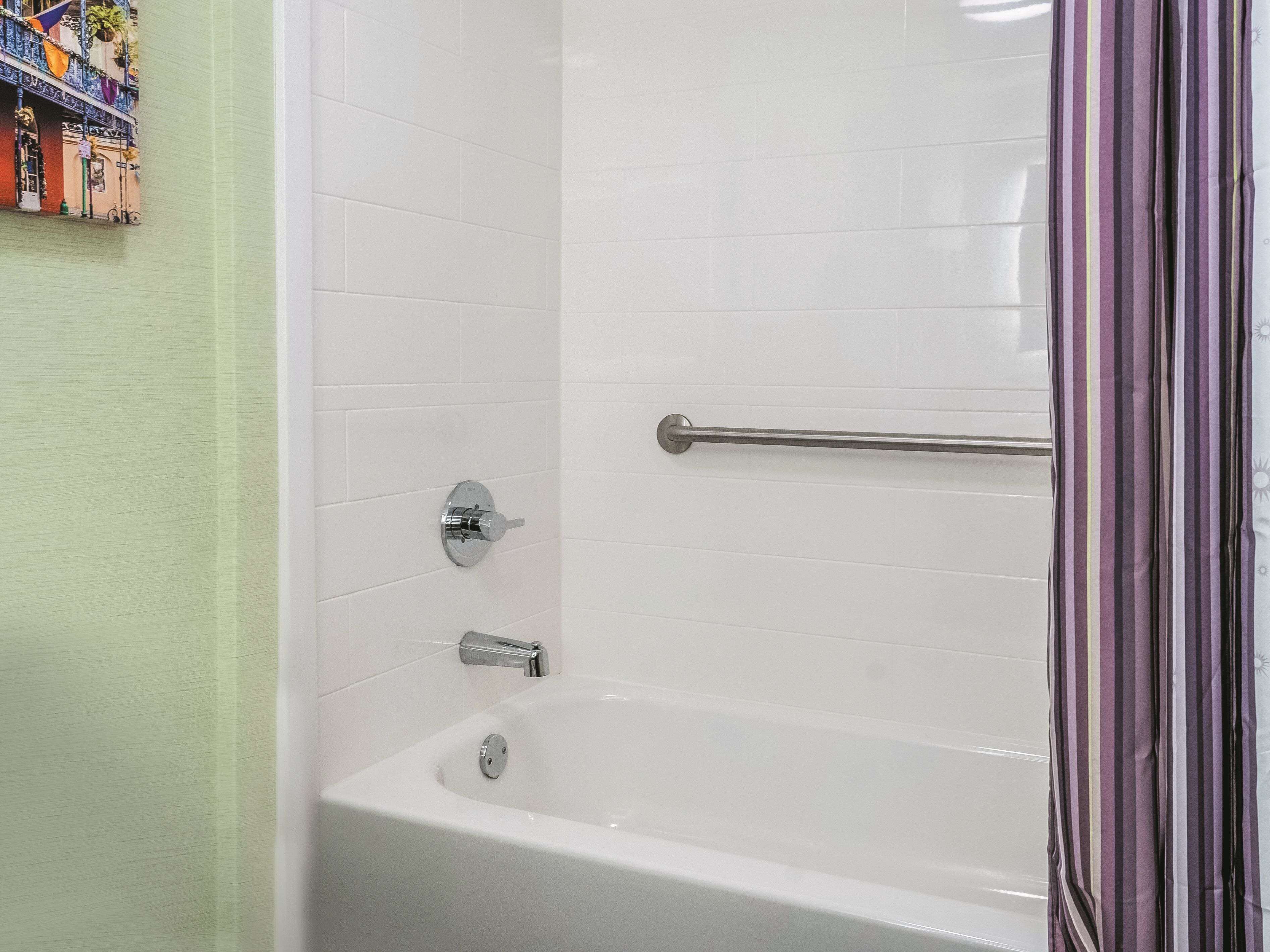 Un baño moderno con baldosas blancas, una bañera y una zona de ducha.