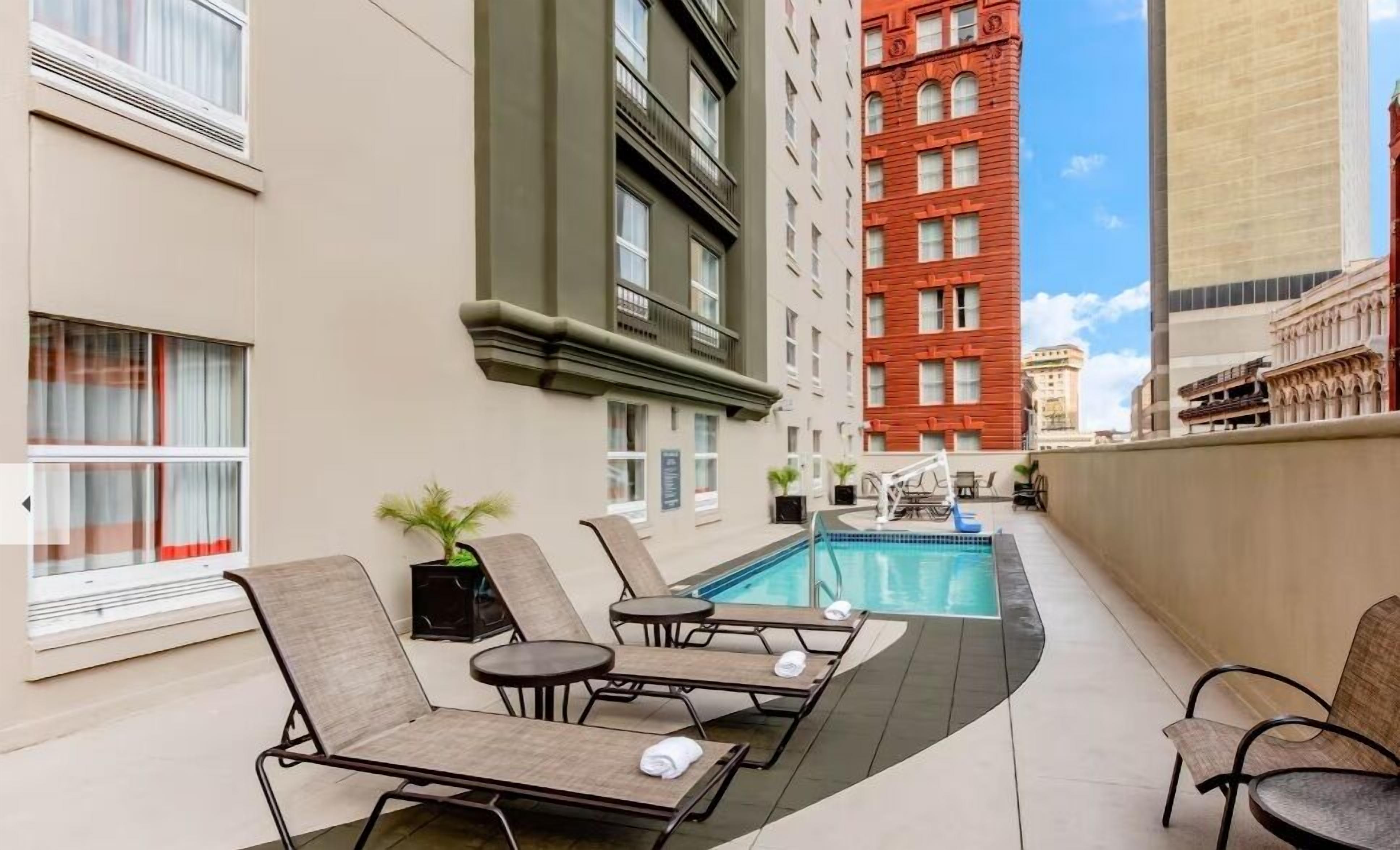 A rooftop pool area with lounge chairs and a small pool.