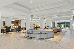 A spacious lobby with a central seating area, a bar, and a view of the outdoors. - Franklin Marriott Cool Springs (Franklin)