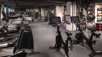 Een sportschool met hometrainers, loopbanden en krachtapparaten.