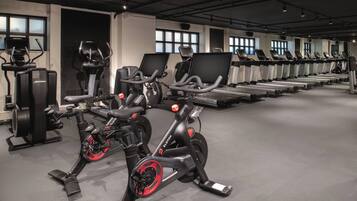 Een fitnessruimte met hometrainers, loopbanden en elliptische trainers.