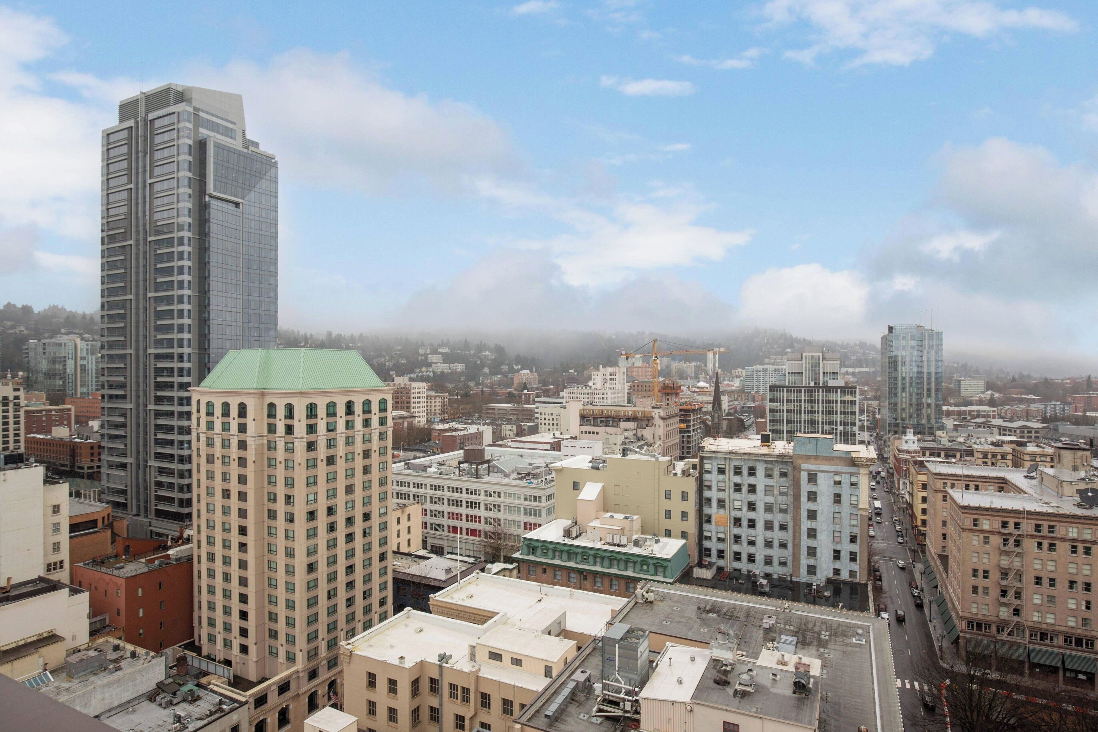 A cityscape with various buildings, including a tall skyscraper and several mid-rise structures.