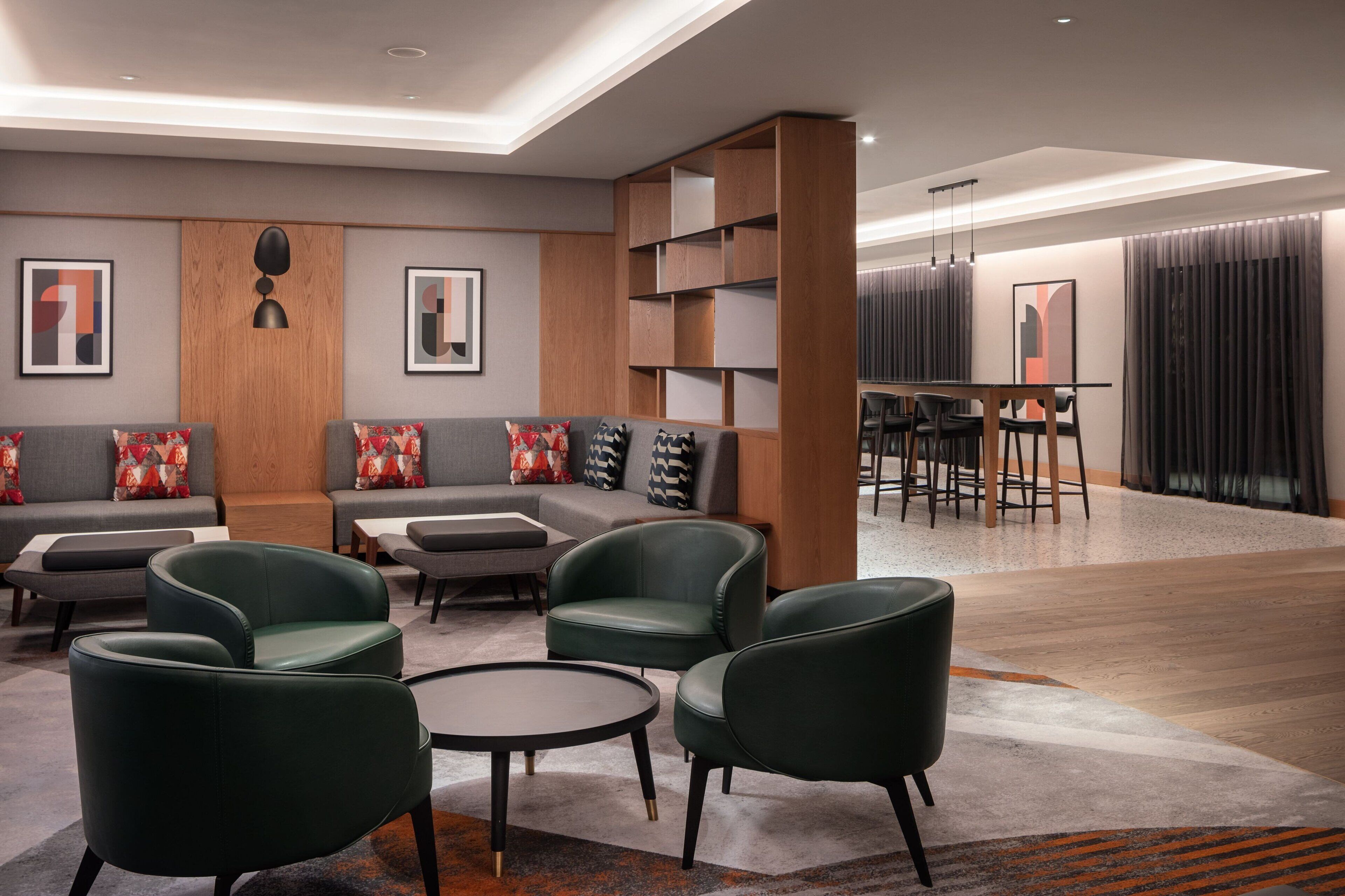 Un área de estar moderna con sofás, sillones y una zona de bar.