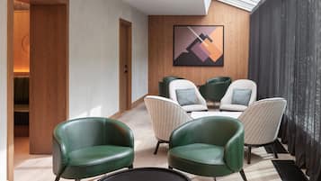 Um interior moderno com área de estar, porta de madeira e uma obra de arte abstrata emoldurada na parede.