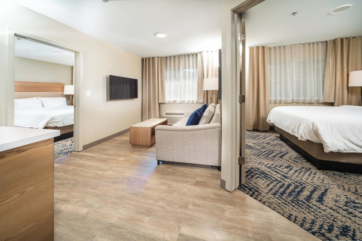 Une chambre d’hôtel avec un lit, un canapé, un bureau et une télévision.