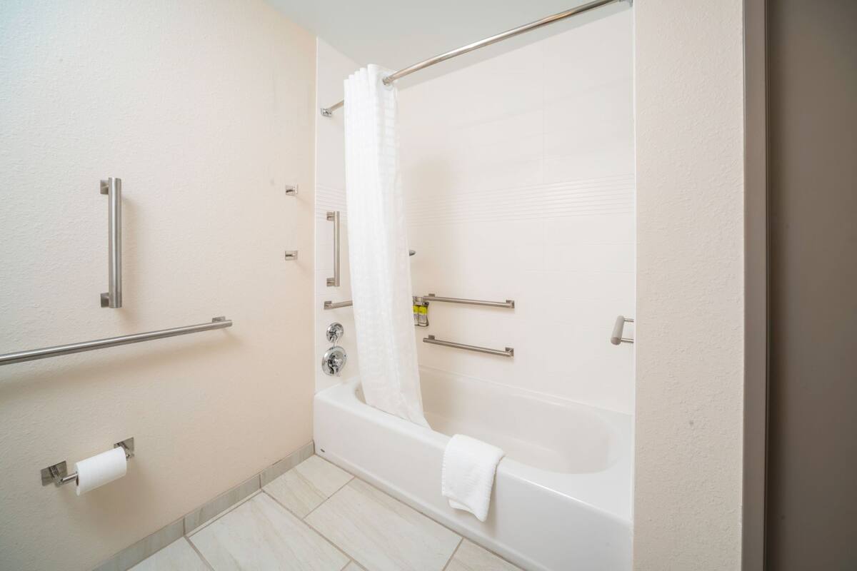 Une salle de bain comprenant une baignoire, des toilettes et un espace douche.