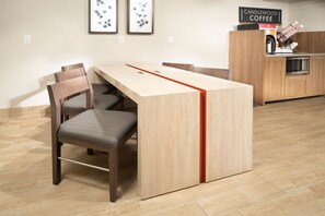 Une cuisine moderne dotée d’un plan de travail en bois, d’un four encastré et d’un espace dédié à la préparation du café.