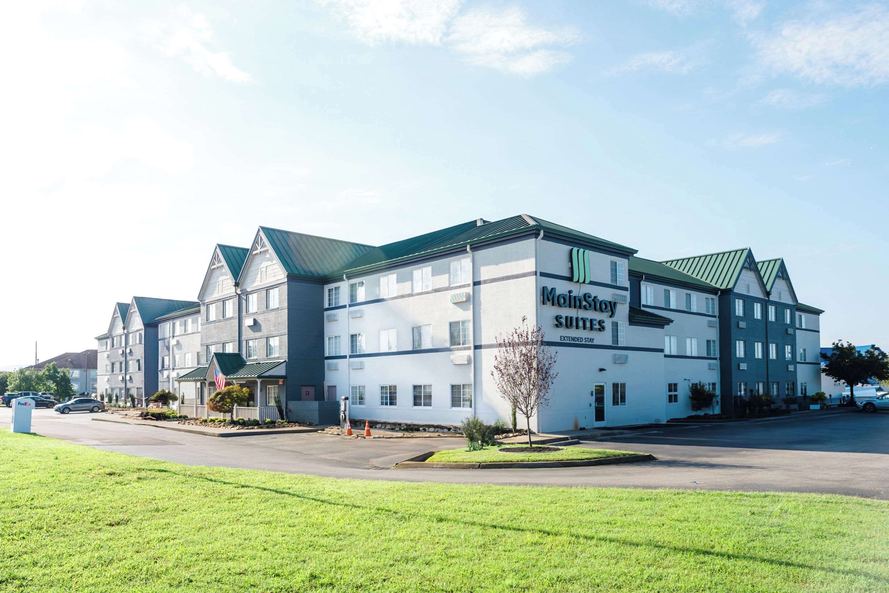 A multi-story motel with a green roof, named 'Mohnstow Suites'.