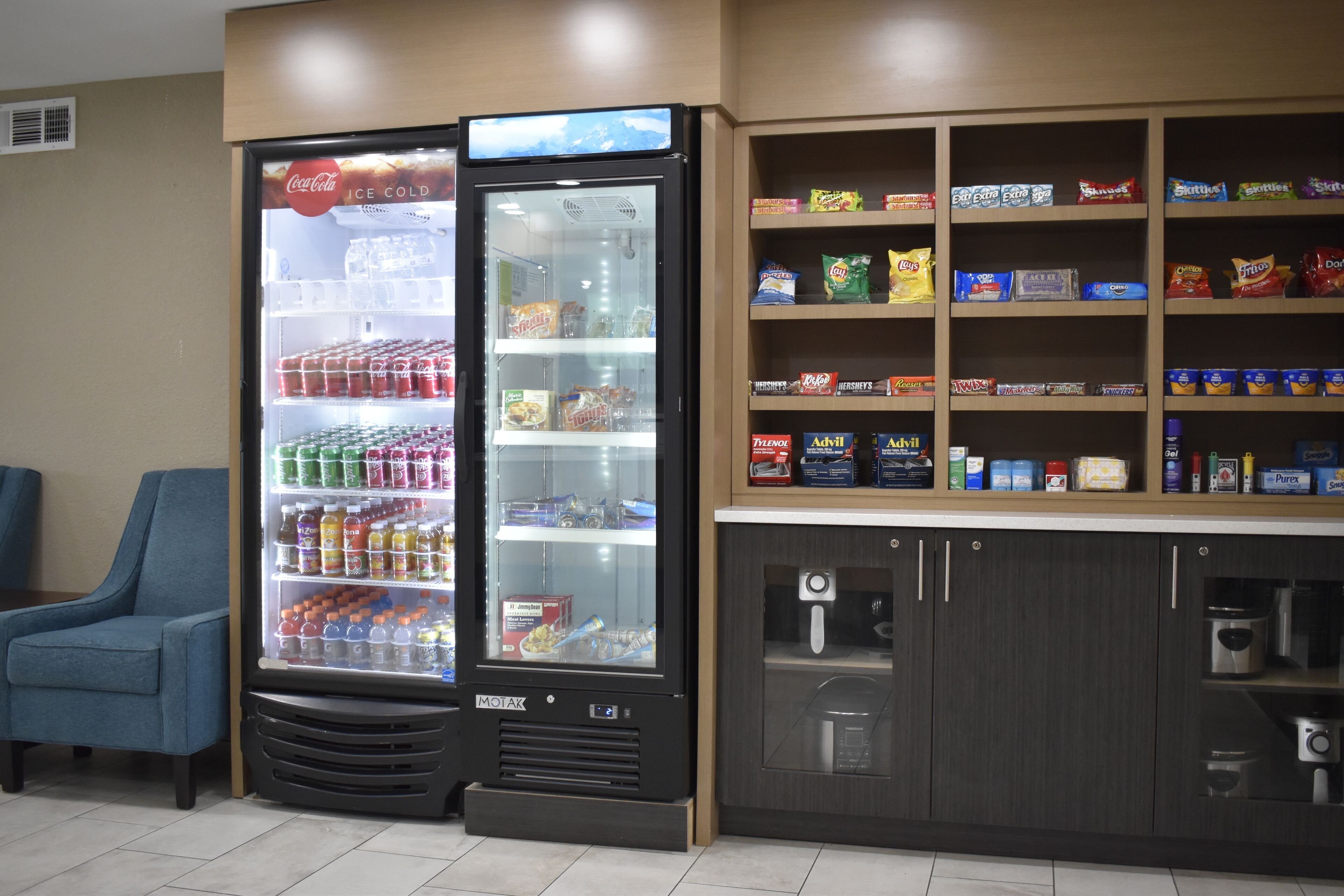 A vending machine with snacks and beverages, a seating area, and a coffee machine.