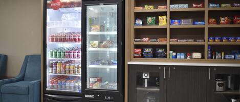 A vending machine with snacks and beverages, a seating area, and a coffee machine.