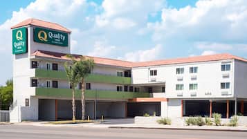 Quality Inn by Clore Hotels features a two-story building with a flat roof and a white facade.