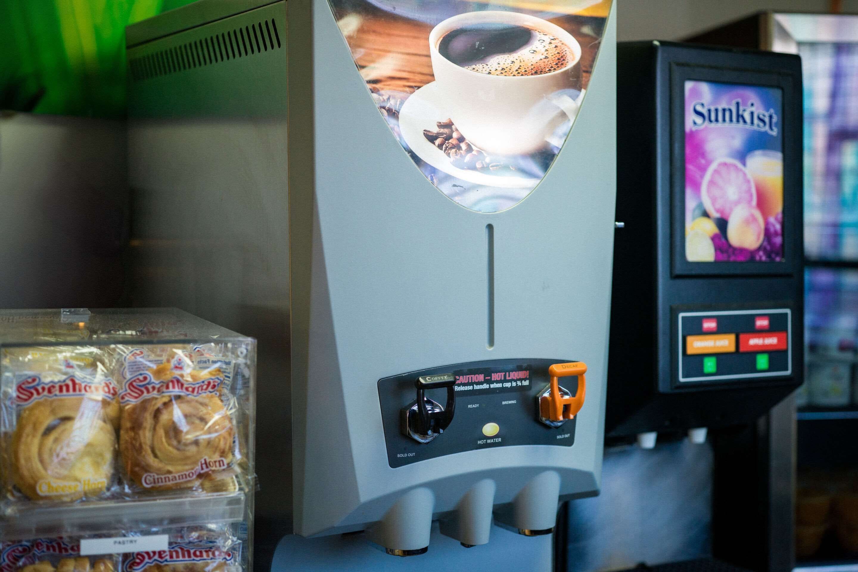 A coffee machine with a display of coffee and a selection of pastries.
