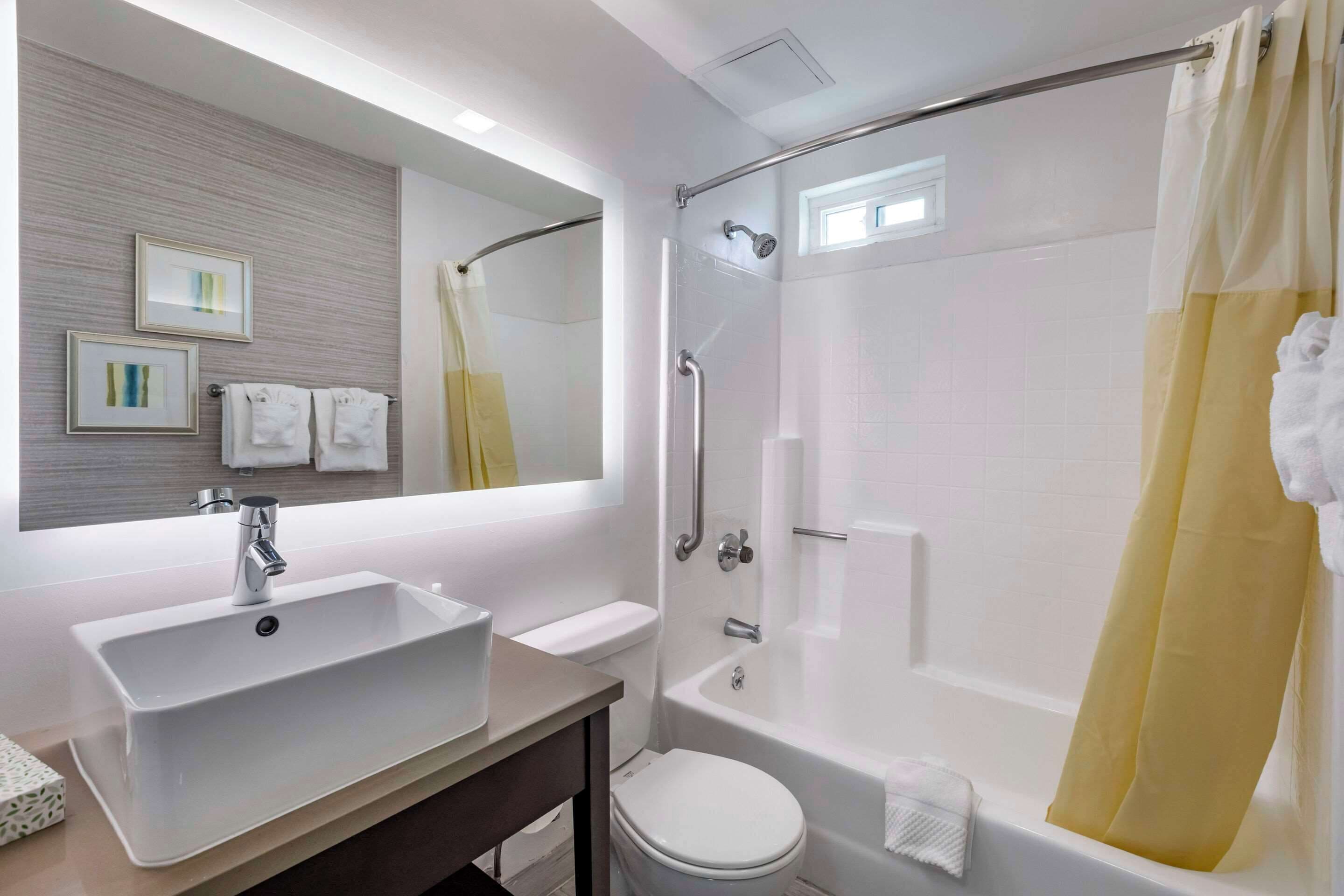 A bathroom with a sink, toilet, and bathtub.