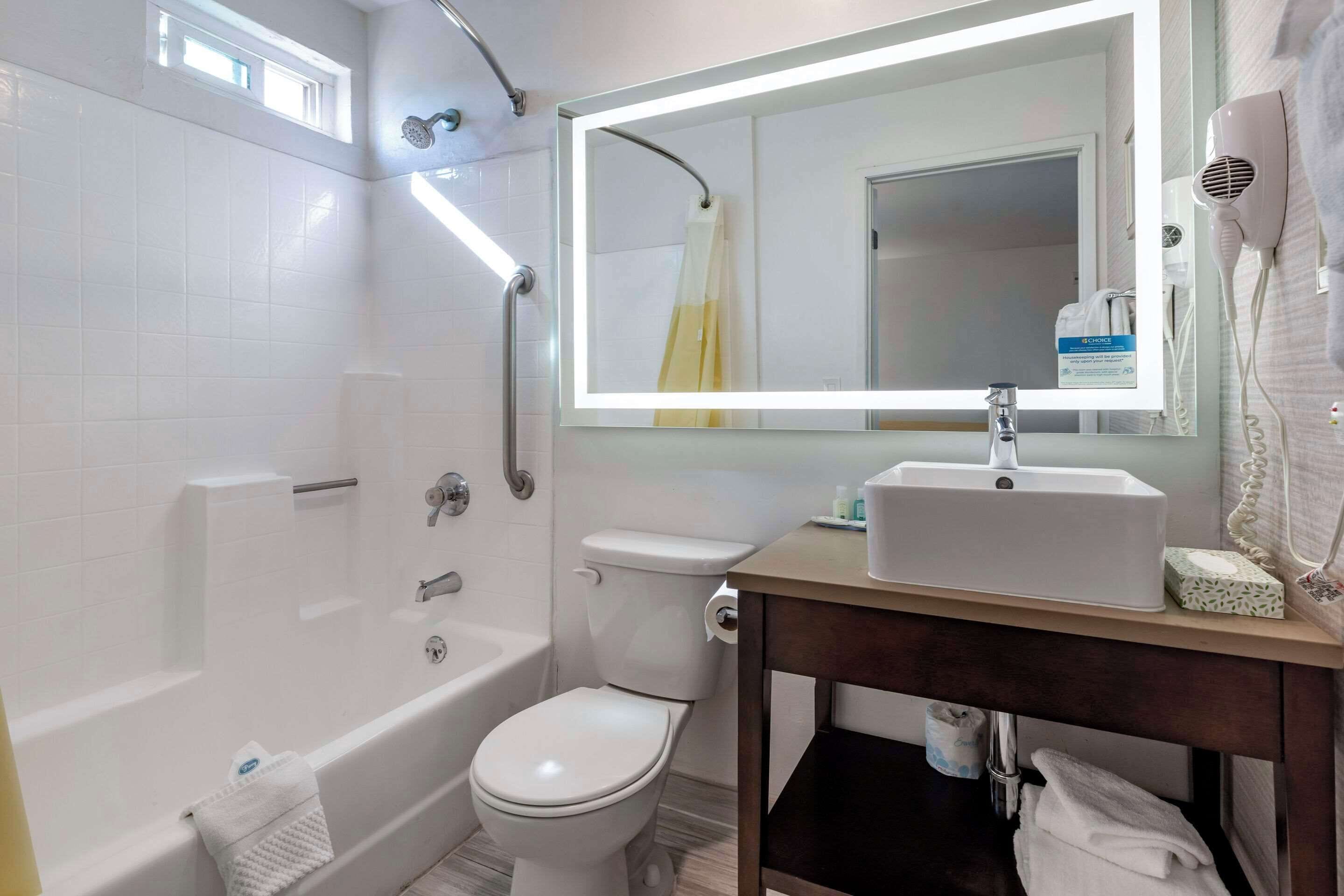A modern bathroom with a bathtub, toilet, and sink.