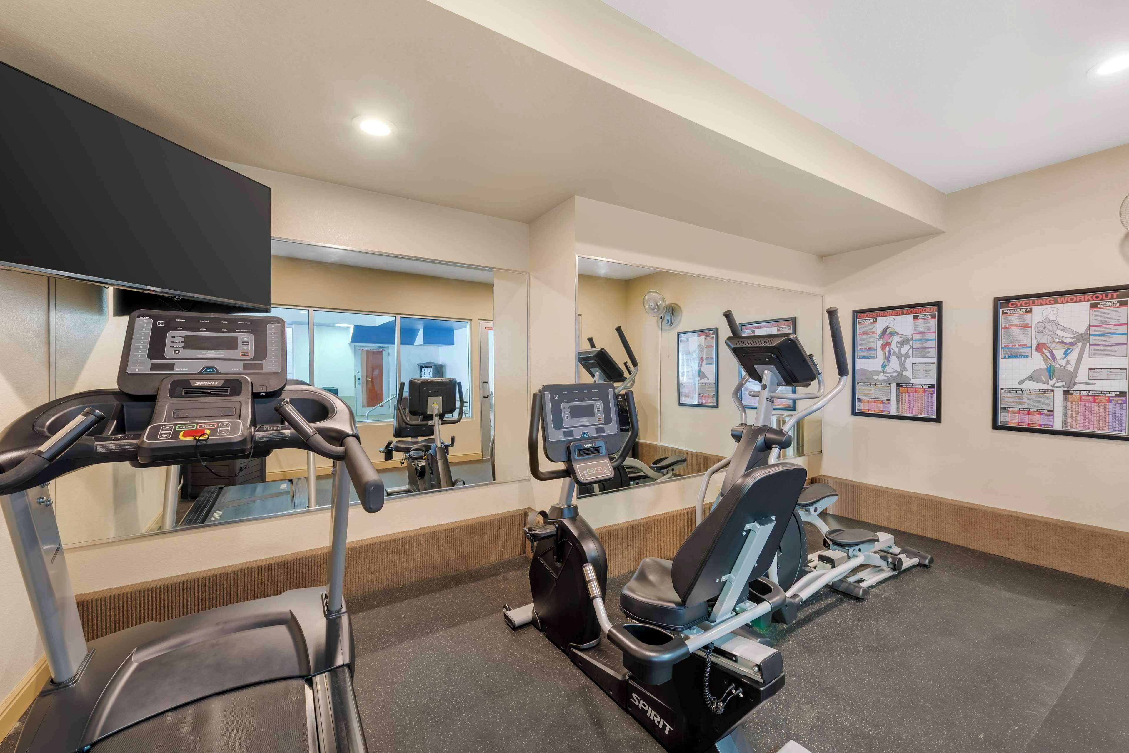 A gym with treadmills, an elliptical, and a stationary bike.