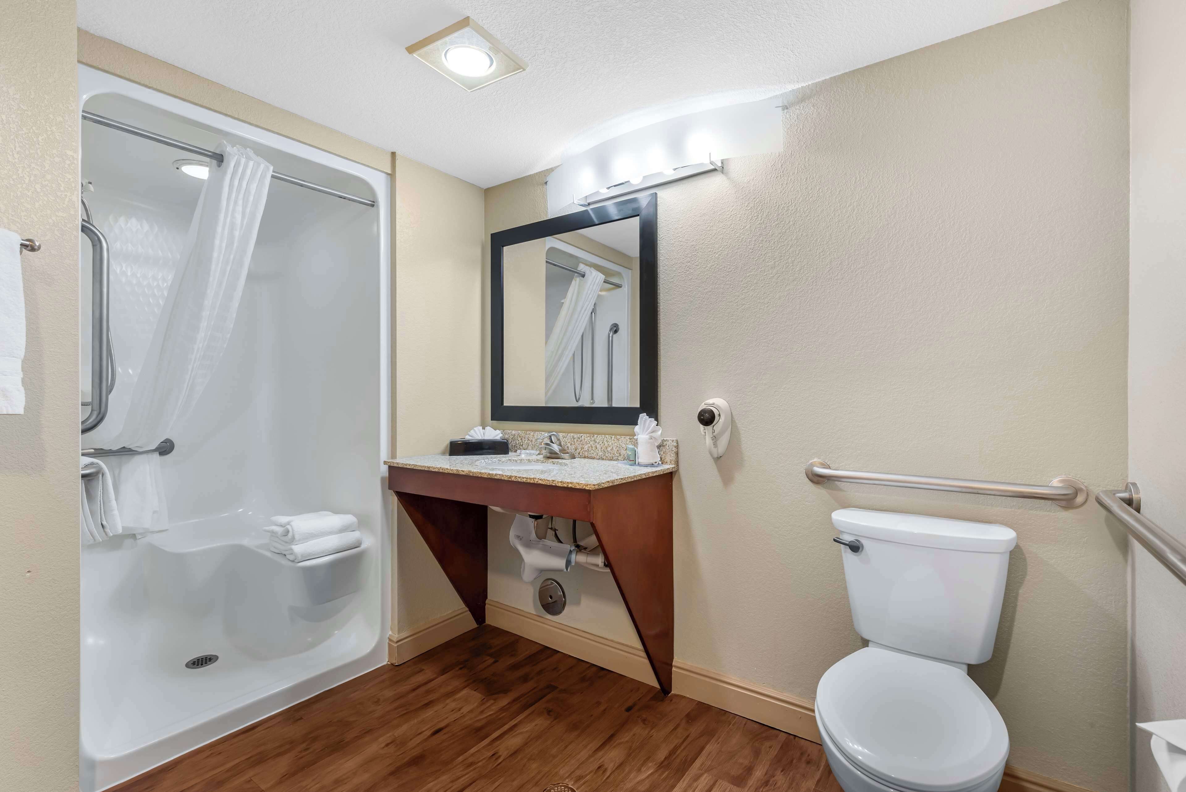 A bathroom with a shower, toilet, and sink.