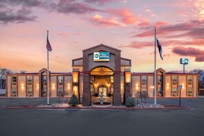 A Best Western hotel with a symmetrical facade, multiple entry points, and a clear sky. - Best Western Executive Inn & Suites (Colorado Springs)