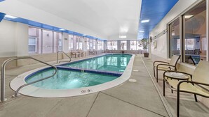An indoor swimming pool with clear blue water, surrounded by lounge chairs and a tiled floor. - Best Western Executive Inn & Suites (Colorado Springs)