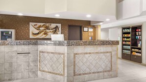 A reception area with a marble counter, a painting on the wall, a door, and a vending machine. - Best Western Executive Inn & Suites (Colorado Springs)