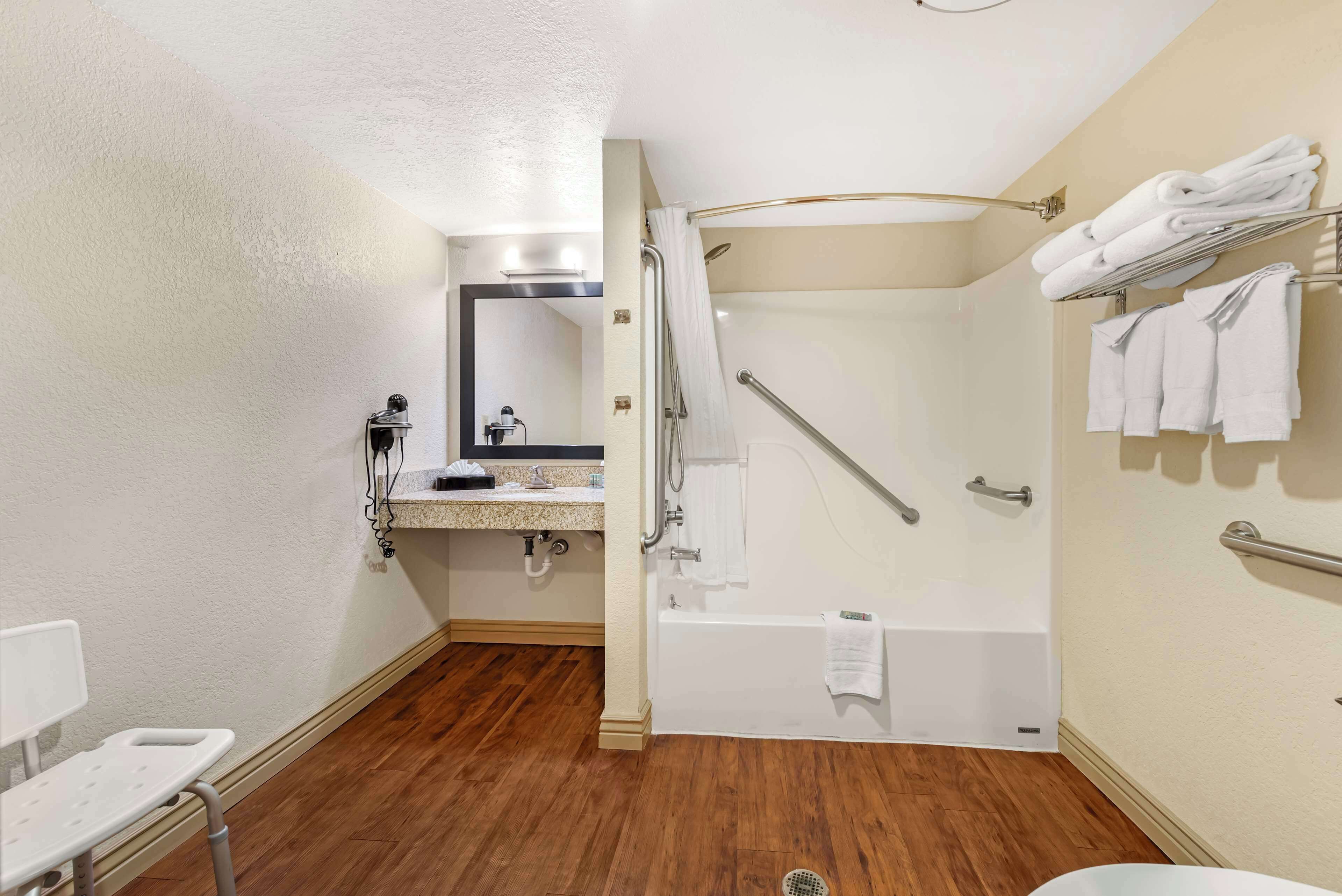 A bathroom with a shower, a sink, and a toilet.