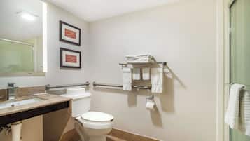 A bathroom with a sink, toilet, and glass shower enclosure.