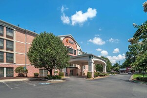 Un hotel Comfort Inn con fachada de ladrillo, un acceso cubierto y un estacionamiento.