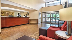 A hotel lobby with a reception desk, seating area, and large windows. - Comfort Inn & Suites Lake Norman (Cornelius)