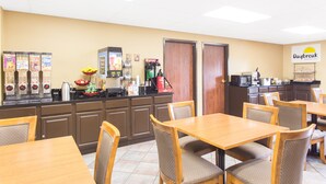 Un área de desayuno con mostrador, máquinas de café y un letrero que dice Daybreak Breakfast.