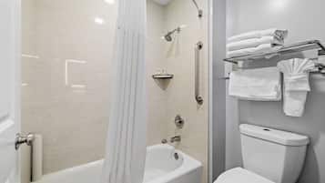A modern bathroom with a bathtub, shower, and toilet.