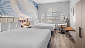 A hotel room with two beds, a large window with blinds, a small table, and a bench. - Hotel Skye SFO (San Bruno)