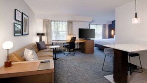 A hotel room with a sofa, a desk with a chair, a TV, a bed, and a small table. - Sonesta ES Suites Atlanta Alpharetta North Point Mall (Alpharetta)