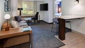 A hotel room with a sofa, a desk, a TV, and a bar area. - Sonesta ES Suites Atlanta Alpharetta North Point Mall (Alpharetta)