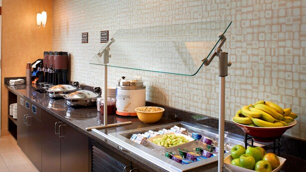Een buffet met verschillende soorten eten, zoals fruit, zuivelproducten en drinken.