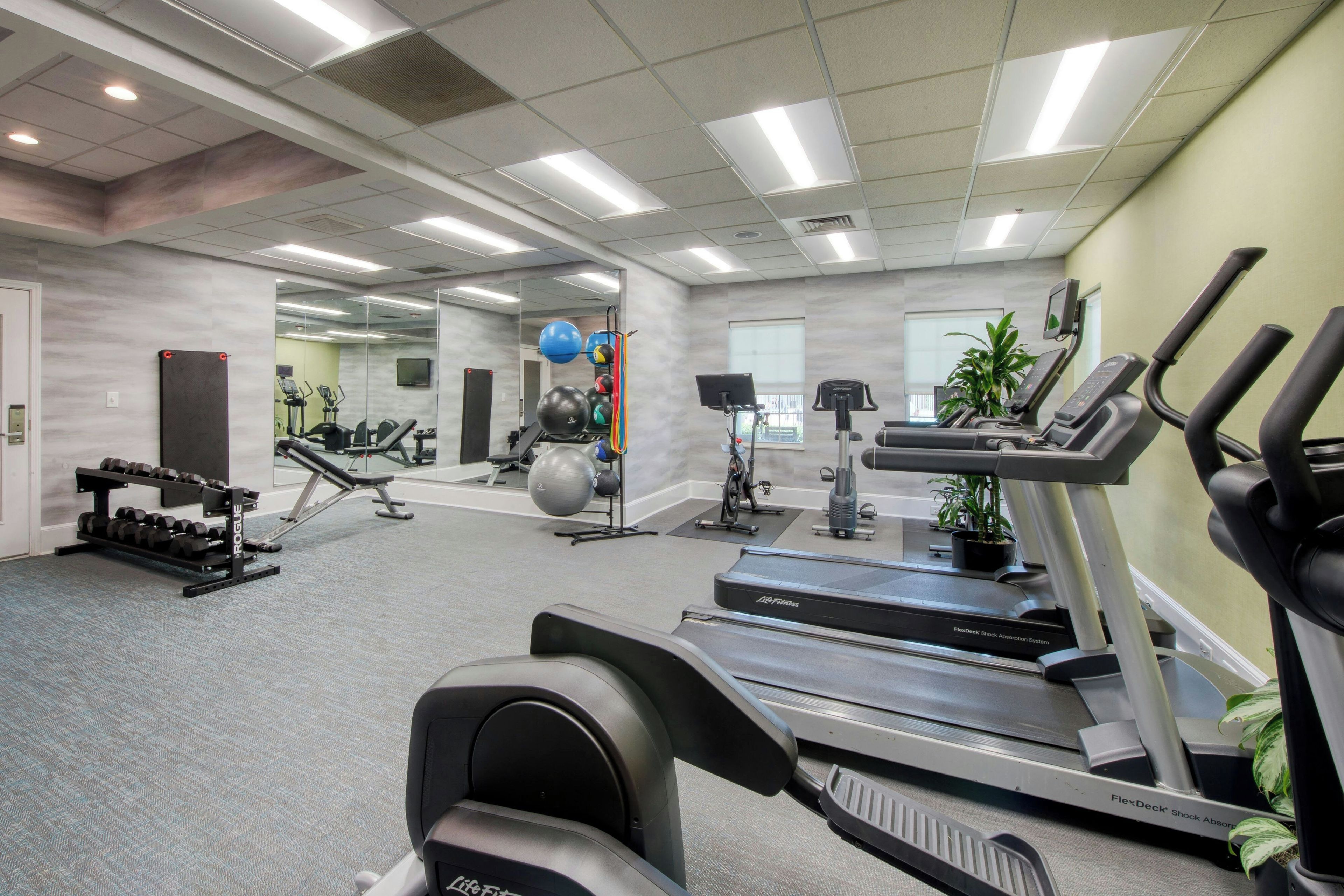 Een sportschool met loopbanden, elliptische trainers en losse gewichten.