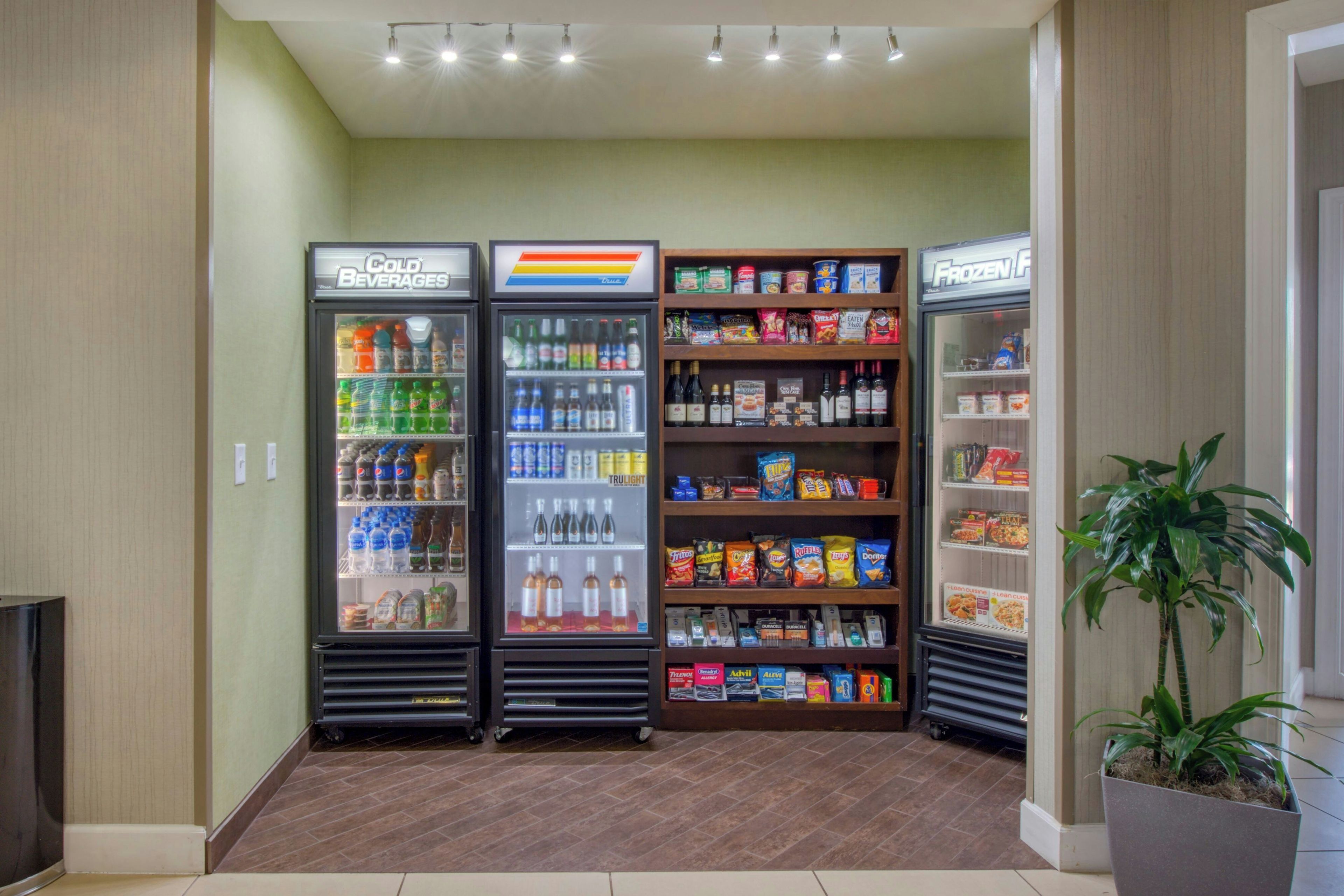 Un área de venta con tres dispensadores de bebidas y estantes con refrigerios.