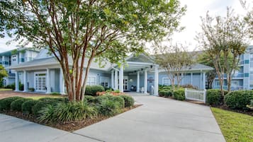Guests enter a welcoming space with a covered porch and beautifully maintained grounds.