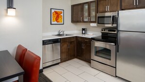 A modern kitchen with stainless steel appliances, wooden cabinets, and a dishwasher. - Residence Inn by Marriott Orlando Convention Center (Orlando)
