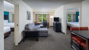 A hotel room with a bed, a sofa, a desk, a TV, and a dining table. - Residence Inn by Marriott Orlando Convention Center (Orlando)