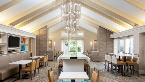 A spacious dining area with high ceilings and modern chandeliers. - Residence Inn by Marriott Orlando Convention Center (Orlando)